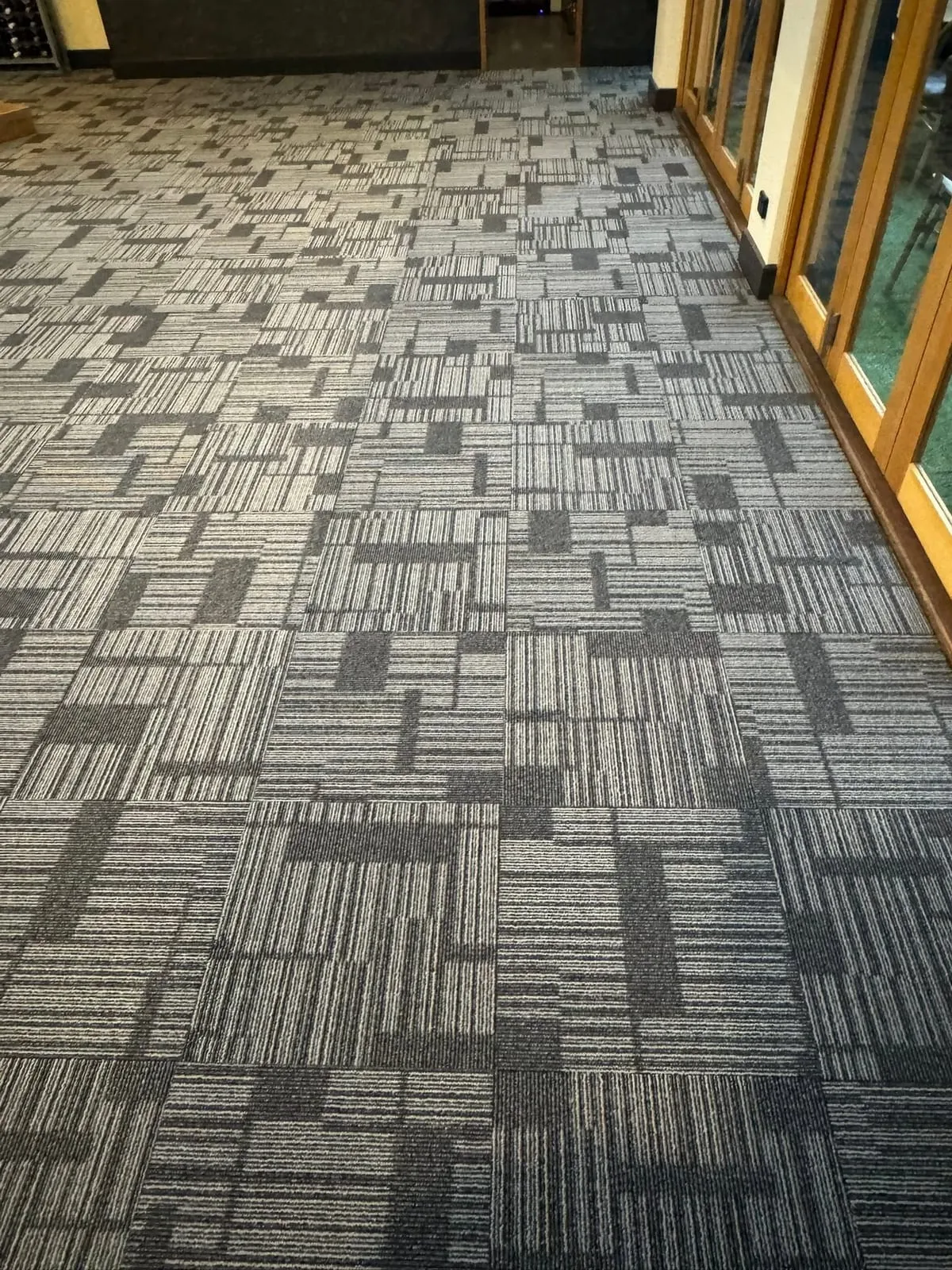 Patterned commercial carpet tiles across a large venue floor