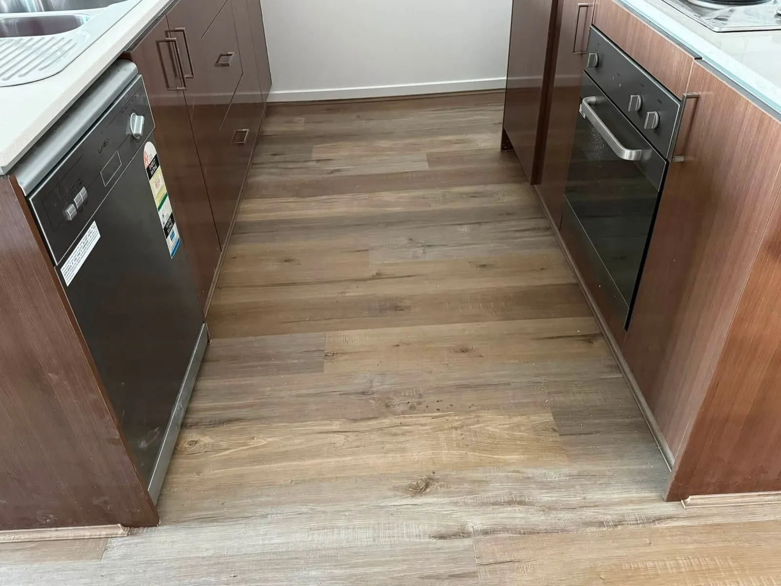 Timber-look hybrid flooring between kitchen cupboards, Footscray