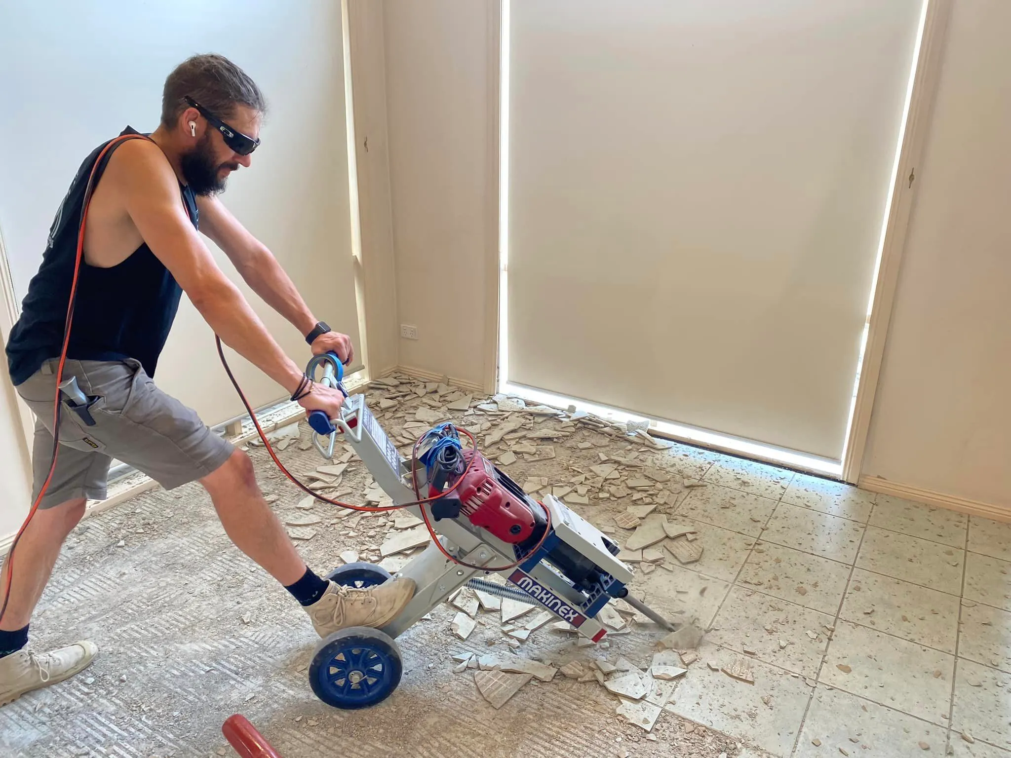 Old tiles being lifted with a floor machine to prepare the concrete for new flooring