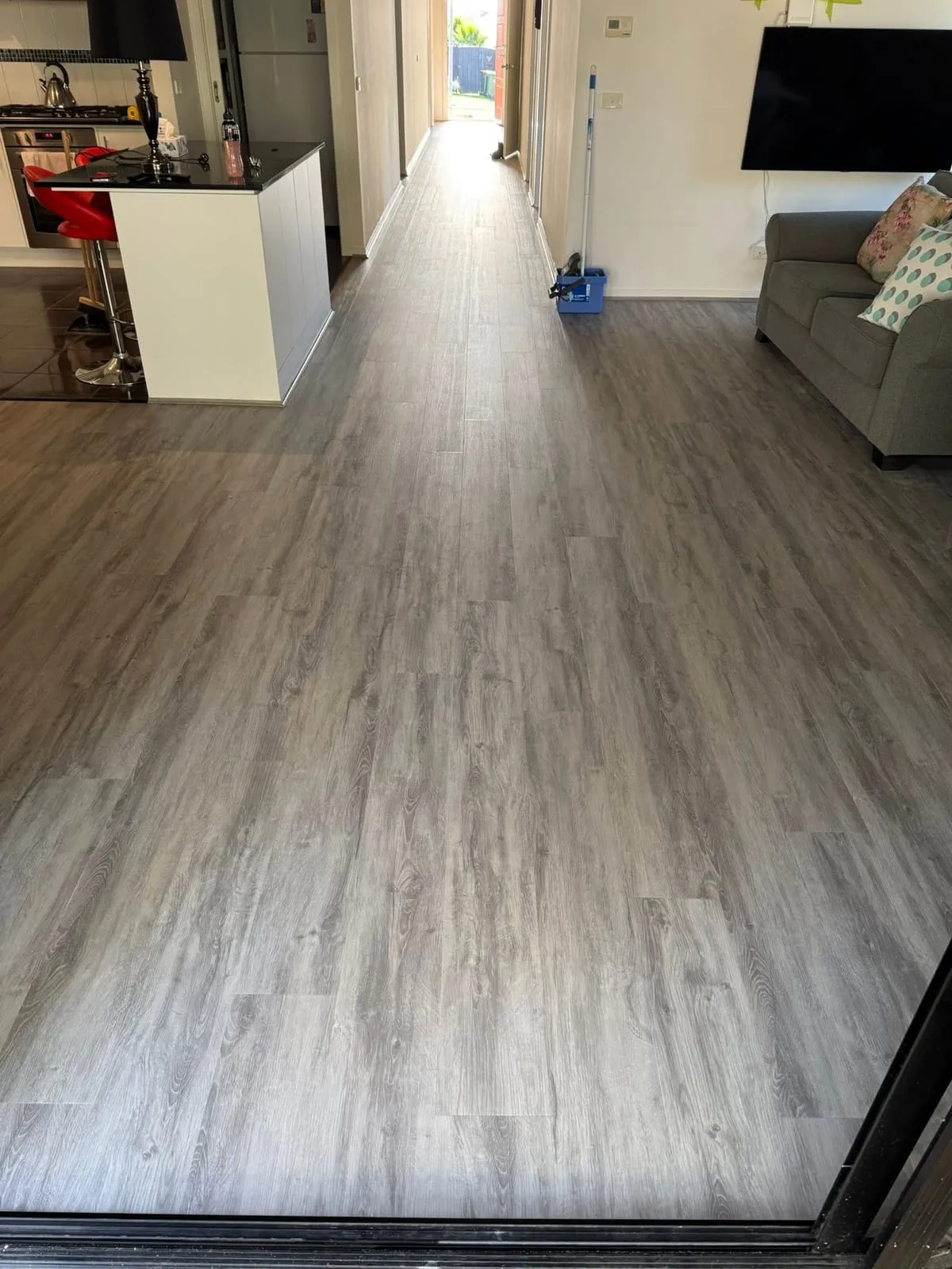 Grey hybrid flooring through a living area, Langwarrin